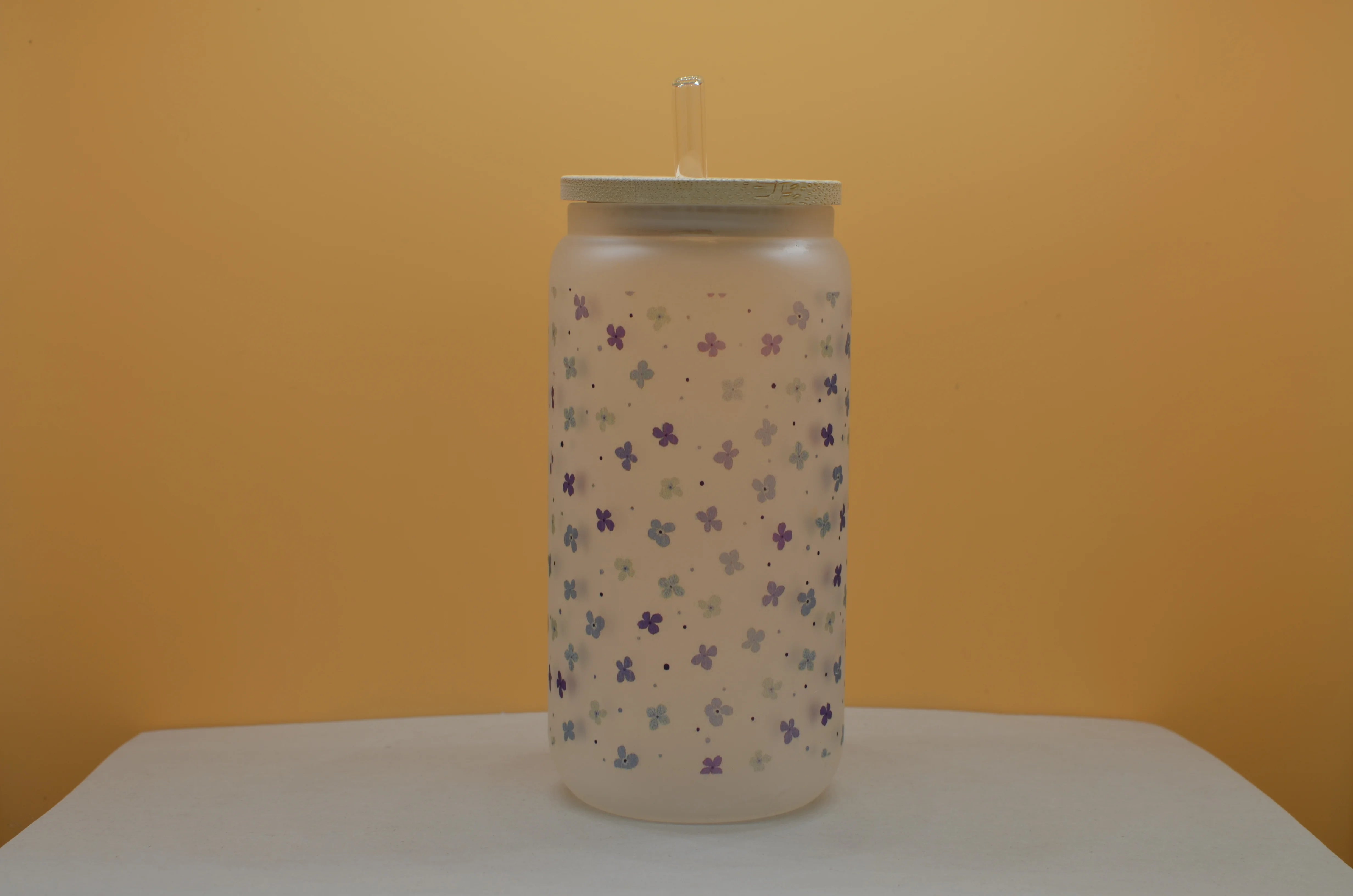 Wrap-around blue floral design on frosted 16oz beer can glass featuring small blue flowers