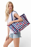 Woman holding a large tote bag with nautical design on a white background