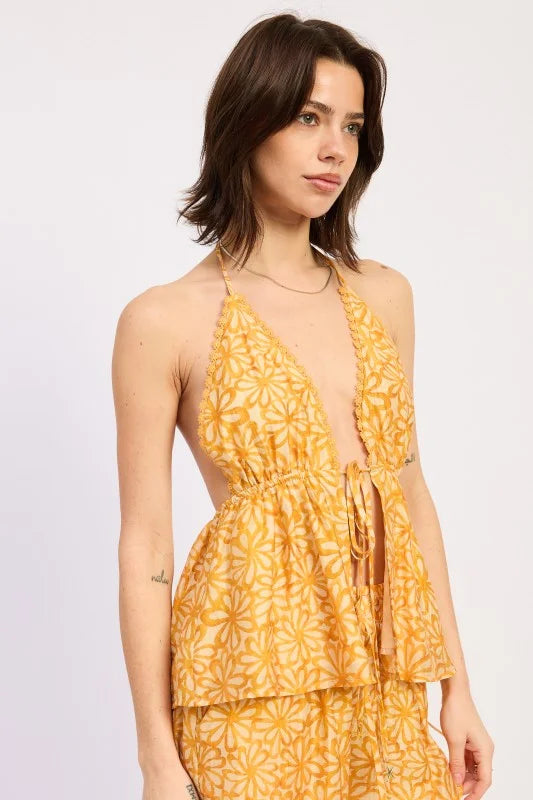 Woman wearing a yellow floral top on a white background