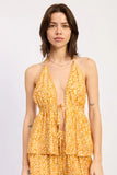 Woman wearing a yellow floral dress on a white background