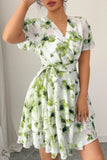 Woman wearing a floral dress with green and white pattern against a neutral background