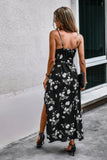 Woman wearing a black floral dress with a white wall and window in the background