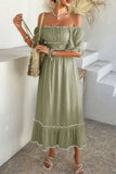 Woman wearing a green off-shoulder dress with white trim in an outdoor setting.