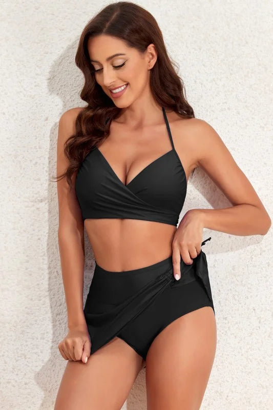 Woman wearing a black swimsuit against a light background