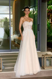 Woman in a strapless nude wedding gown standing on a porch.