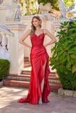Woman in a red evening gown standing in an ornate garden setting