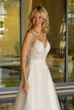 Woman wearing a white lace wedding dress standing outdoors.