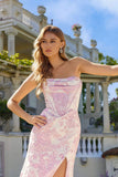 A woman with long wavy hair models the Juliet JT2737A, a strapless floral prom dress featuring a corset bodice and thigh-high slit, standing outdoors in front of a grand building with columns and balconies.