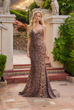 A woman wears the Juliet JT2734H, a leopard print dress featuring a lace-up back, standing in an outdoor setting with classical architecture and greenery.