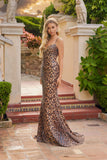 A woman wears the Juliet JT2734H, a leopard print dress featuring a lace-up back, standing in an outdoor setting with classical architecture and greenery.
