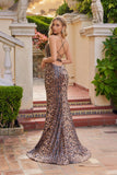 A woman wears the Juliet JT2734H, a leopard print dress featuring a lace-up back, standing in an outdoor setting with classical architecture and greenery, looking over her shoulder.