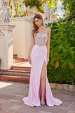 A woman wears the Long Prom Dress: Juliet JT2729H in baby pink with a strapless beaded bodice and high leg slit, standing outdoors near steps and greenery.