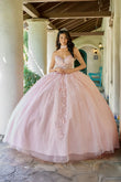 Woman in a pink quinceañera dress standing in a decorated outdoor setting.