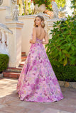 A woman wearing the Juliet JT2735H long prom dress stands outdoors by stairs and greenery, looking over her shoulder at the camera.