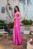 Woman wearing the elegant Juliet JT2698A long prom dress—a pink strapless satin gown with a fitted corset bodice and flared skirt standing on a patio with decorative elements.