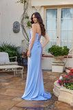 Woman in the Juliet JT2698A long prom dress—a blue strapless satin gown with a fitted corset bodice and flared skirt standing outdoors in front of a building with plants and furniture.