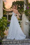 A woman stands outdoors on stone steps, looking over her shoulder in the Juliet JT2740S Long Prom Dress—a strapless vintage polka dot gown with a sweetheart neckline and flowing A-line skirt.