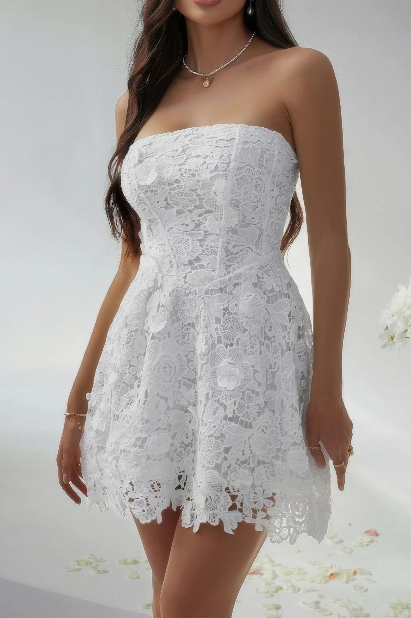 White lace strapless dress worn by a model on a white background