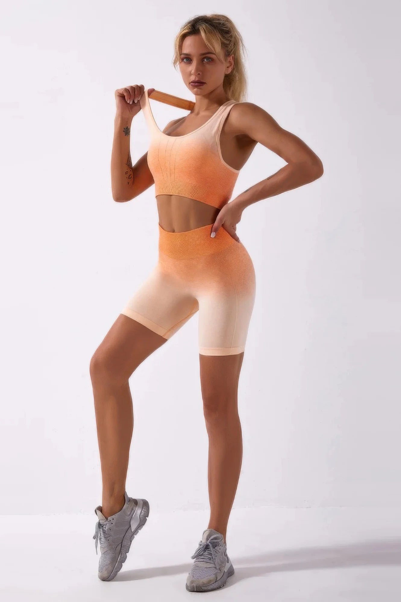 Woman wearing a peach sports bra and shorts set on a white background