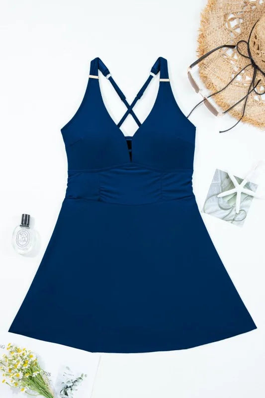 Blue swimsuit dress with criss-cross straps on a white background