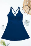 Blue swimsuit dress with criss-cross straps on a white background