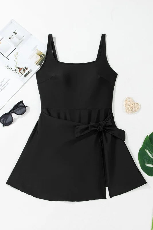 Black swim dress with a bow tie on a white background