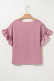 Pink blouse with ruffled sleeves on a wooden hanger against a white background