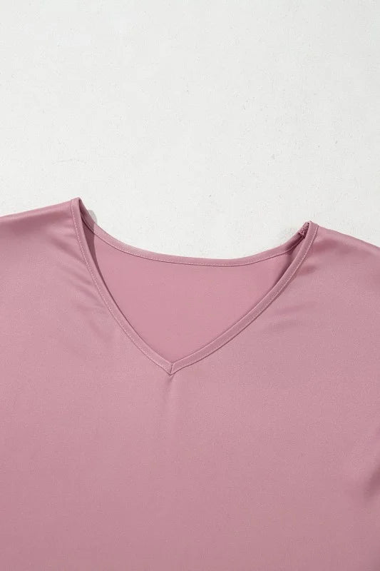 Close-up of a pink garment with a V-neck on a light gray background