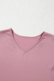 Close-up of a pink garment with a V-neck on a light gray background