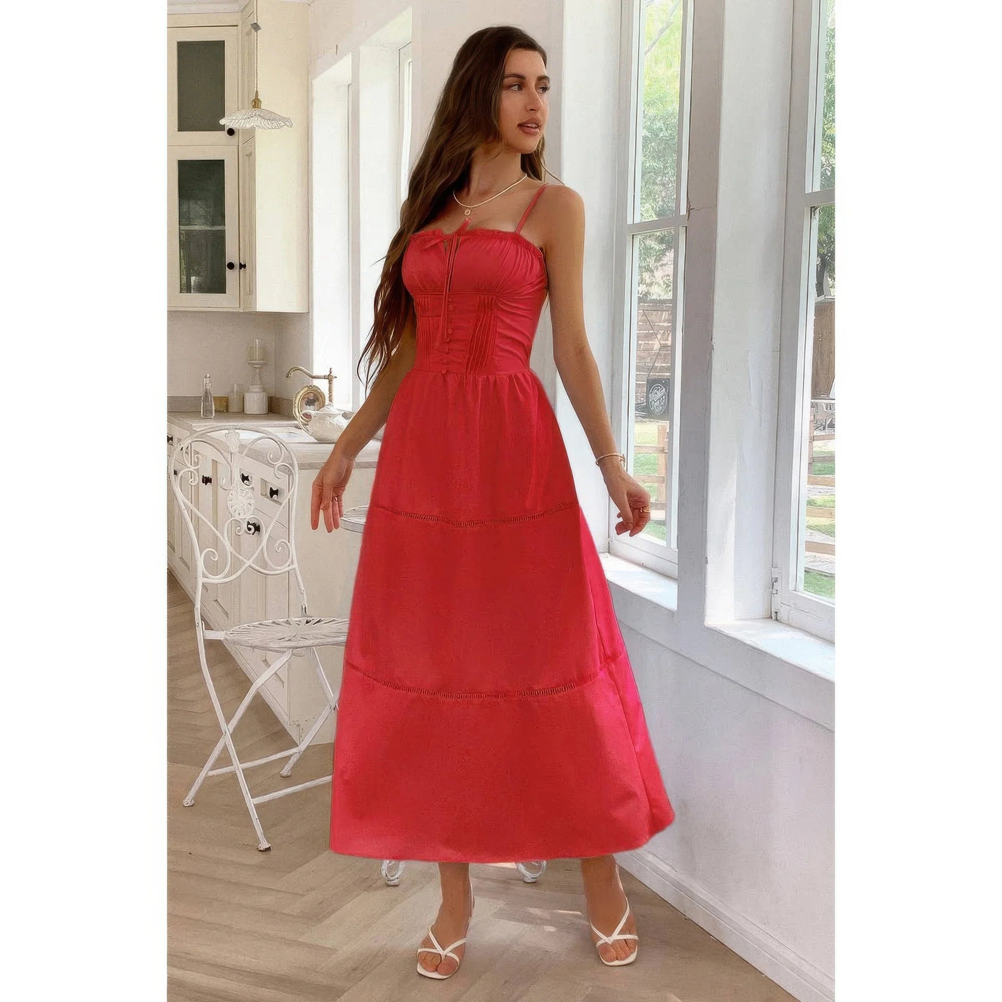 Woman in a red dress standing in a bright kitchen.