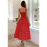 Woman wearing a red dress in a bright room with large windows.