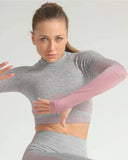 Woman wearing a gray long-sleeve top and pink arm sleeves on a white background