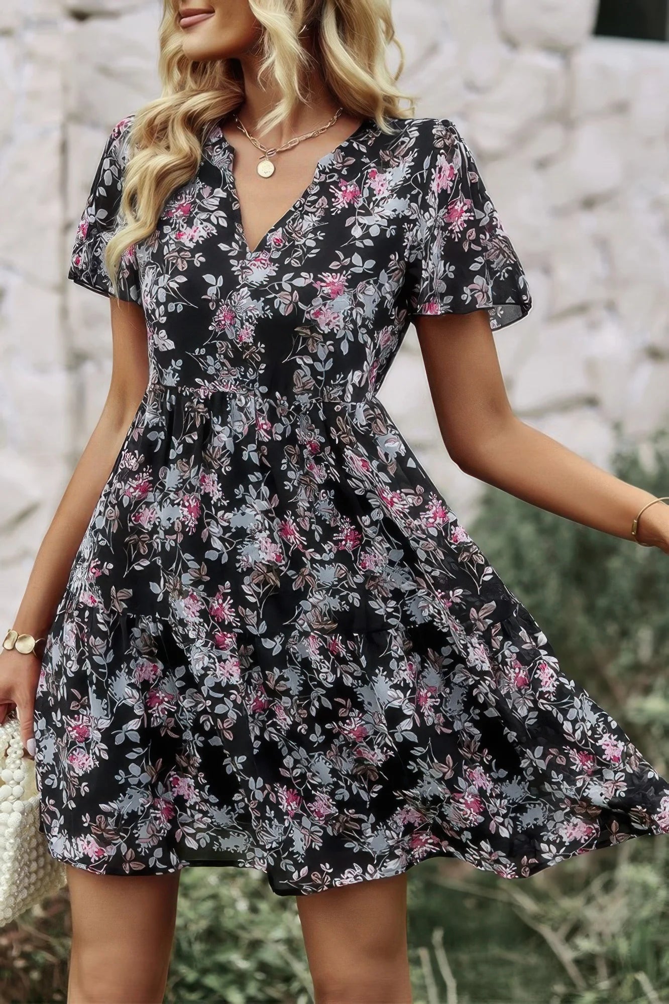 Woman wearing a black floral dress with a blurred background