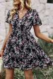 Woman wearing a black floral dress with a blurred background